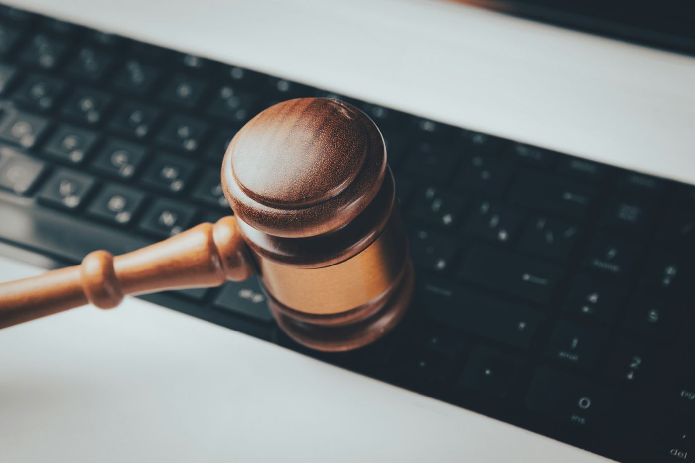 A wooden legal gavel above a computer keyboard